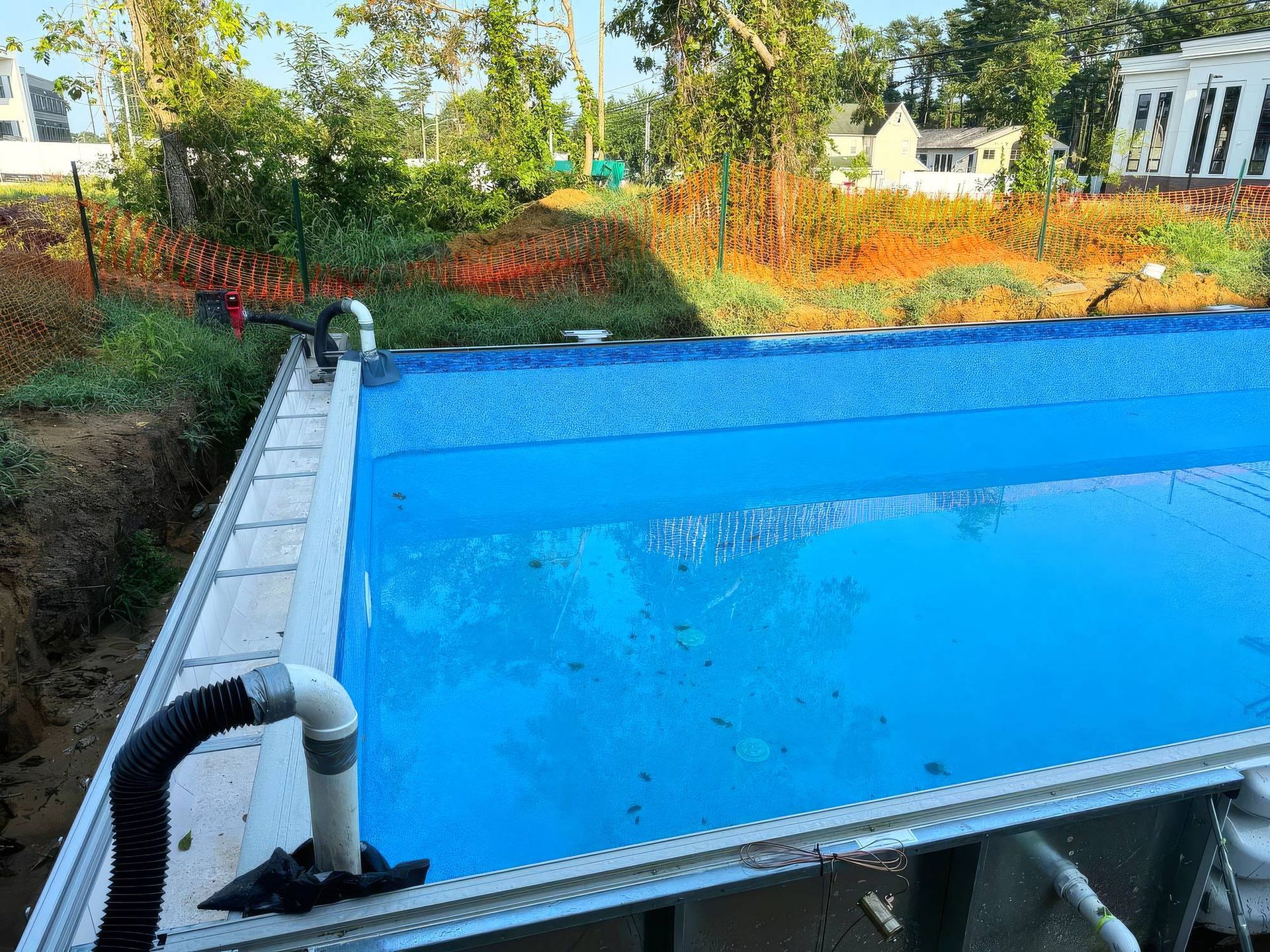 A large swimming pool is being built in a backyard. A large swimming pool is being built in a backyard.