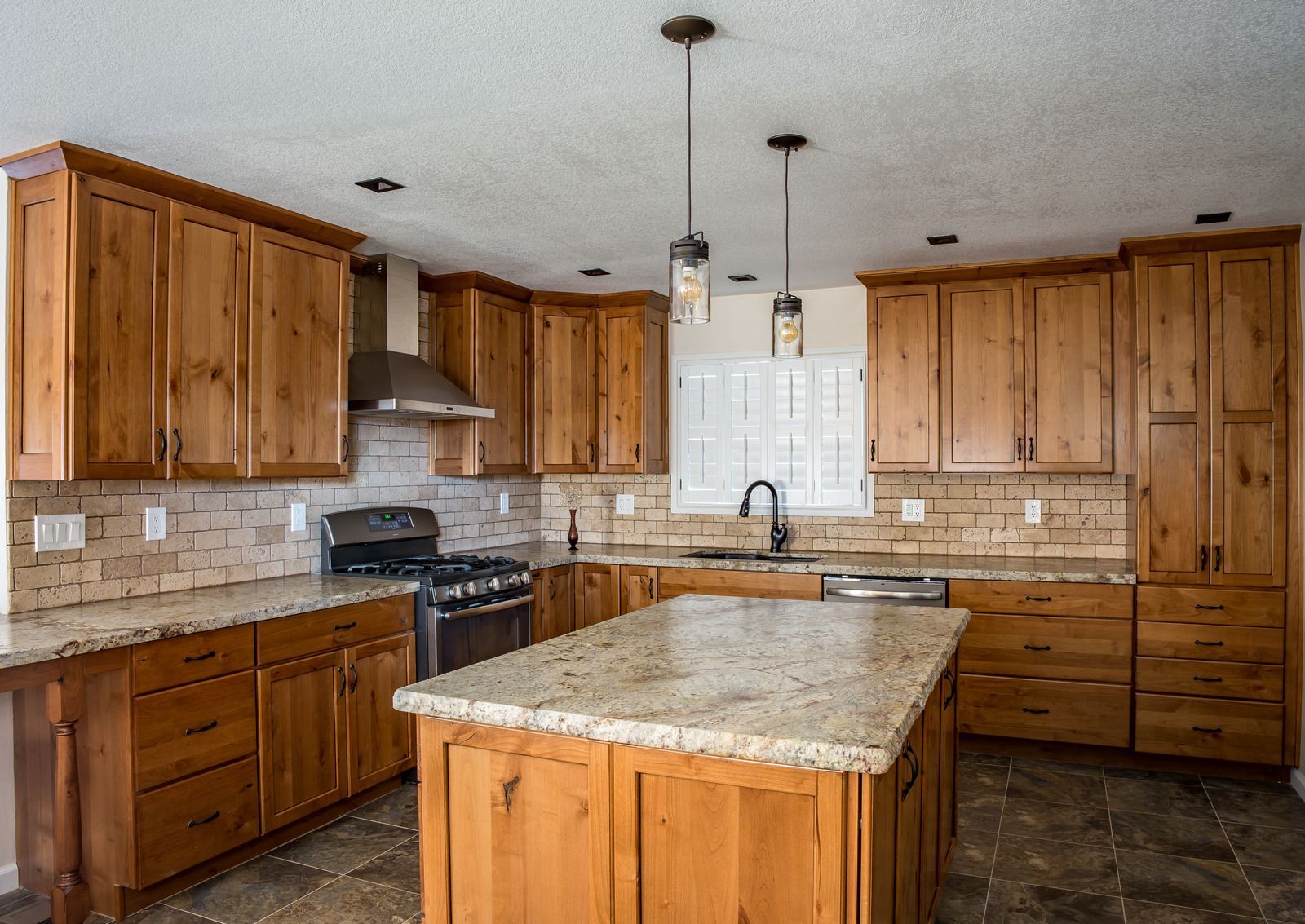 Spacious kitchen with light wood cabinets, granite countertops, and an island.