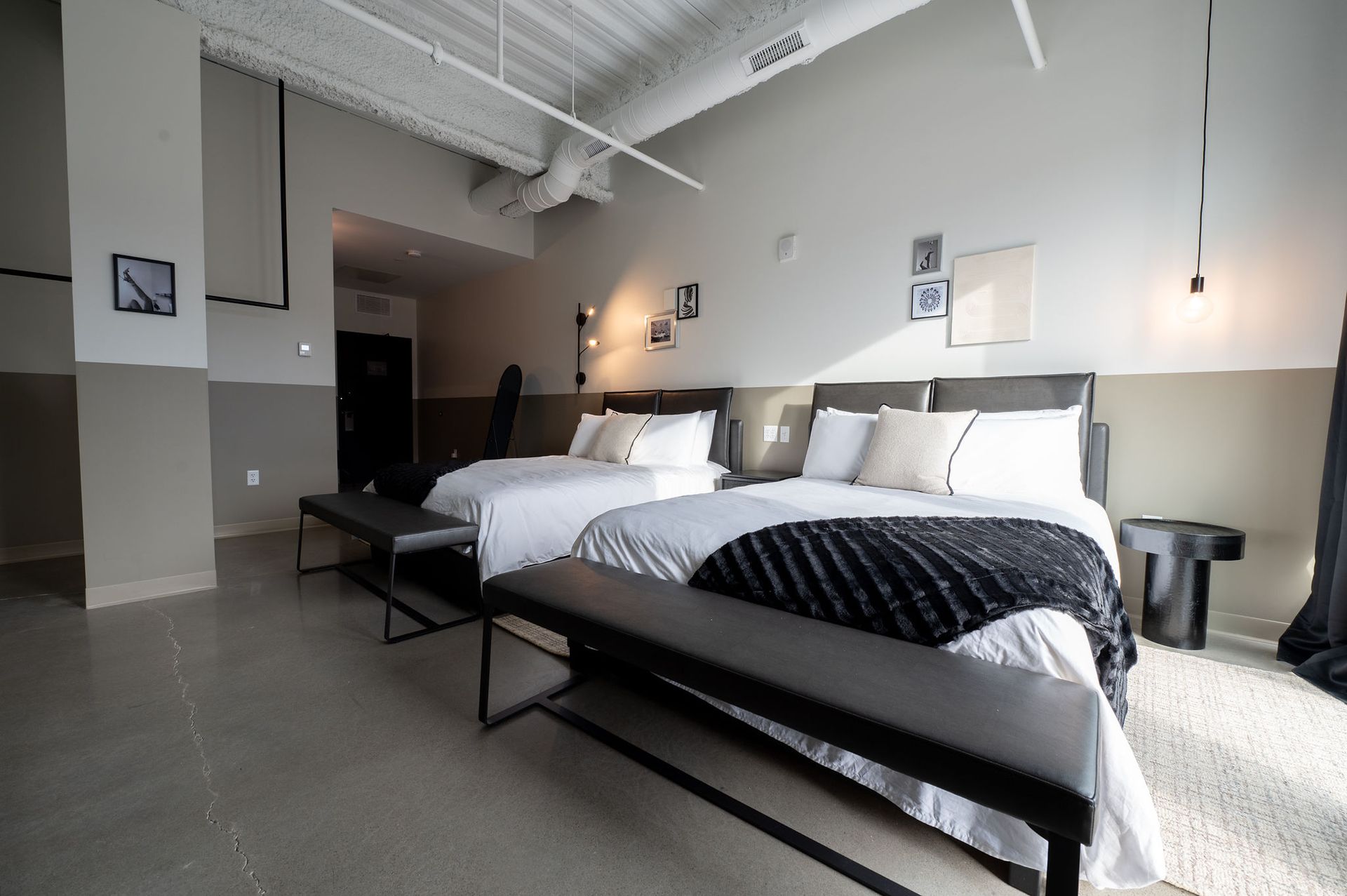 Modern hotel room with two neatly made beds, white bedding, and minimalist decor