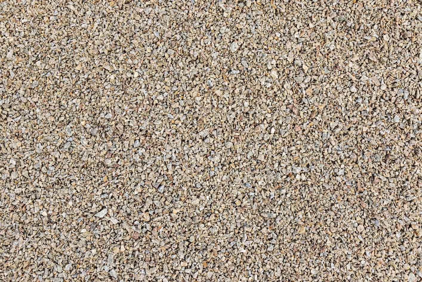 Speckled tan and brown gravel or sand texture filling the frame