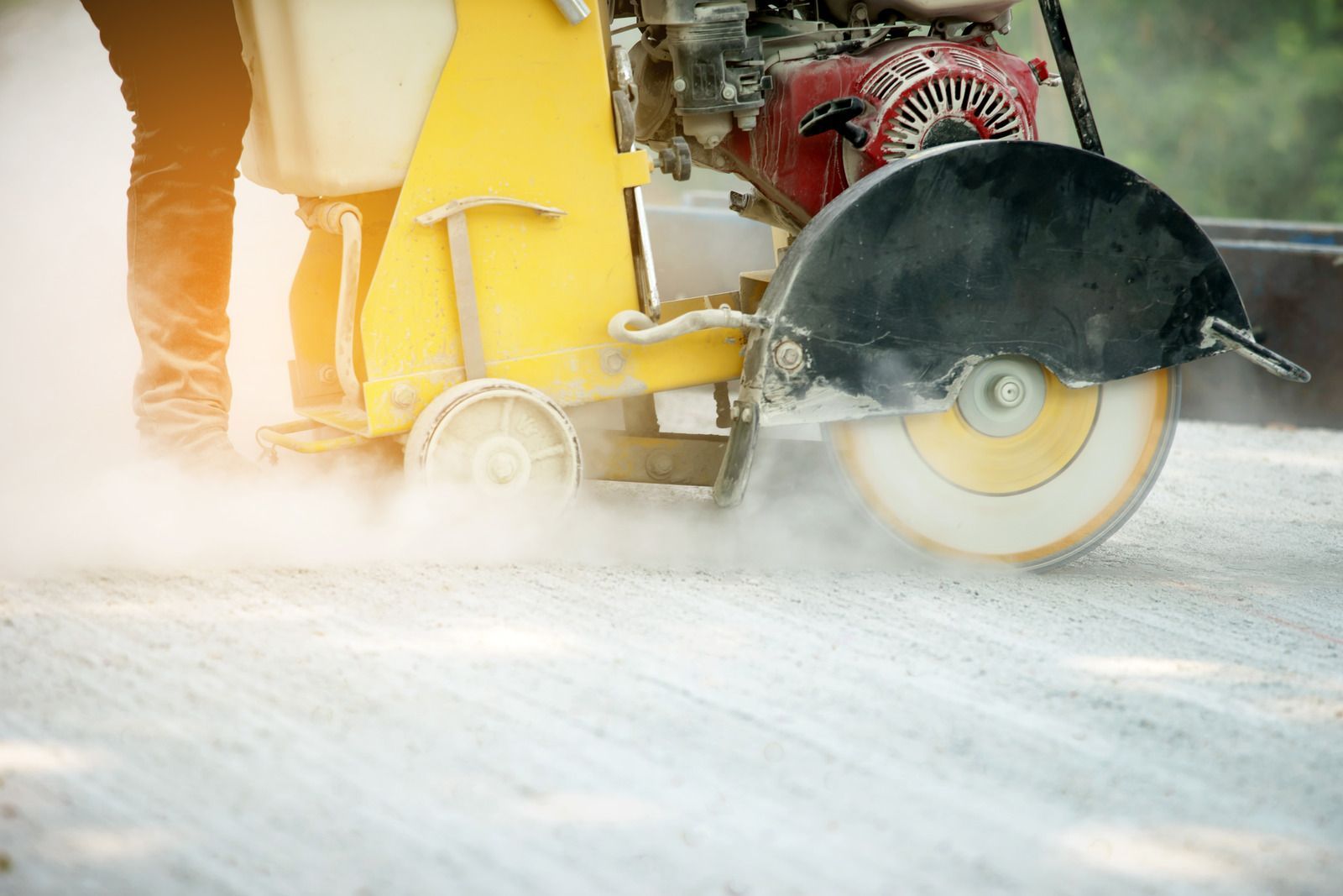 Construction workers pouring concrete at a building site, with a truck in the background