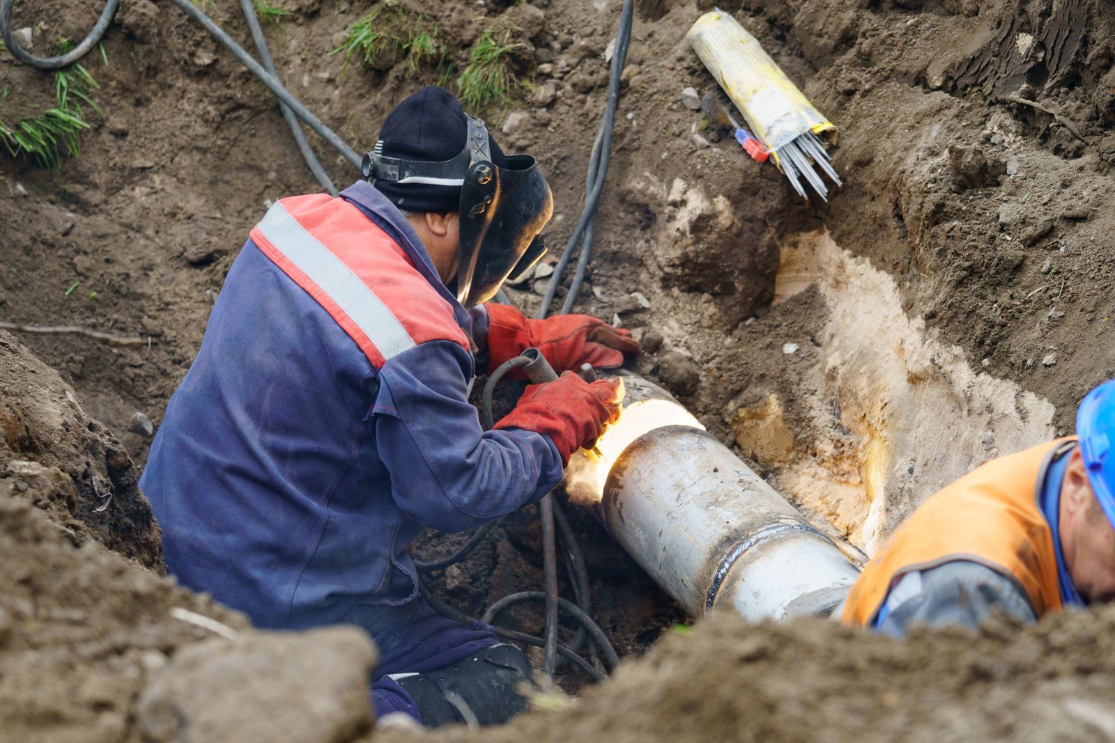 Wet concrete pouring from a truck chute onto a construction site, forming a gravelly slab surface