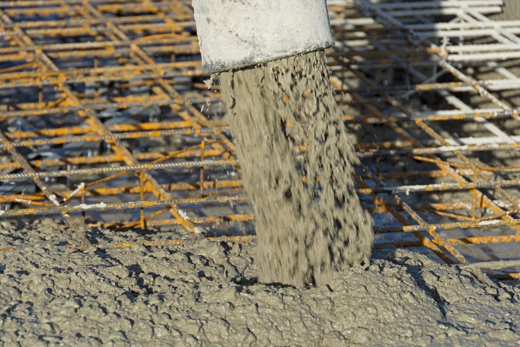 Cantiere stradale con strati di ghiaia e pietrisco stesi per la preparazione di una fondazione.