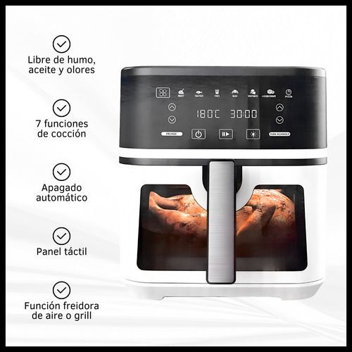 Horno freidora de aire en blanco y negro con pan en su interior y una bandeja extraíble con verduras asadas al lado.