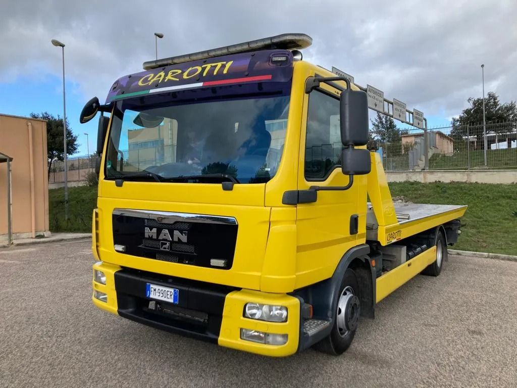 Yellow MAN tow truck parked outdoors on a road, front-left view.