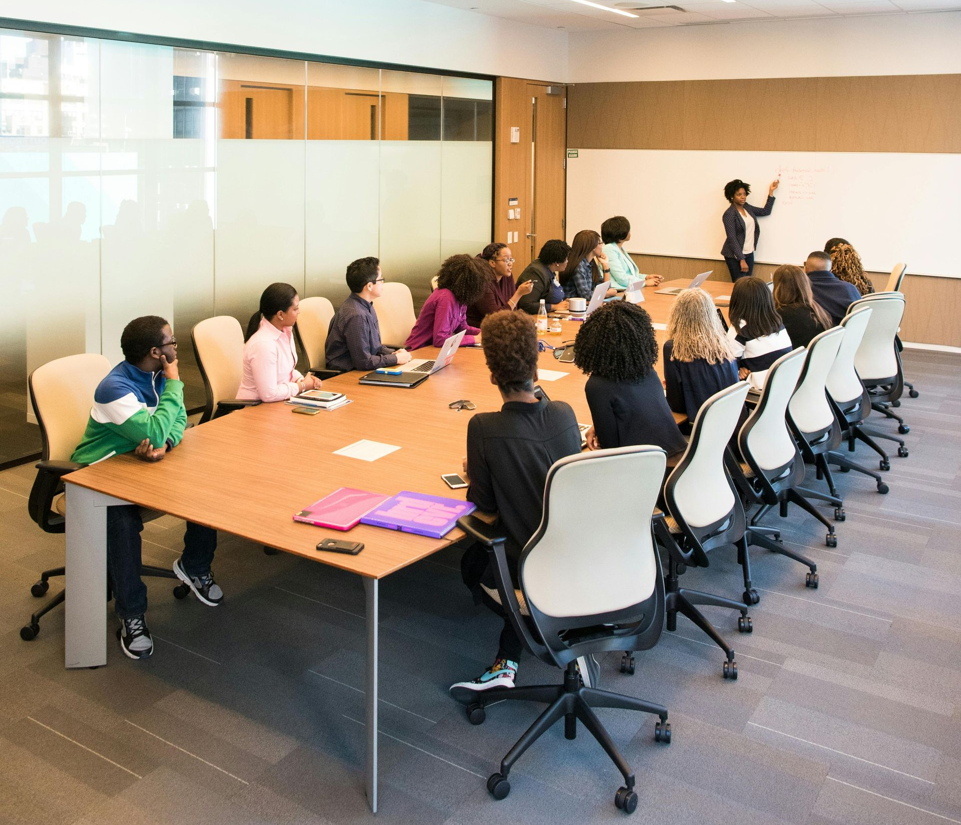 People in a conference room, listening to a presentation. Someone stands at the whiteboard, pointing. Alot of energy being used. People in a conference room, listening to a presentation. Someone stands at the whiteboard, pointing. Alot of energy being used.