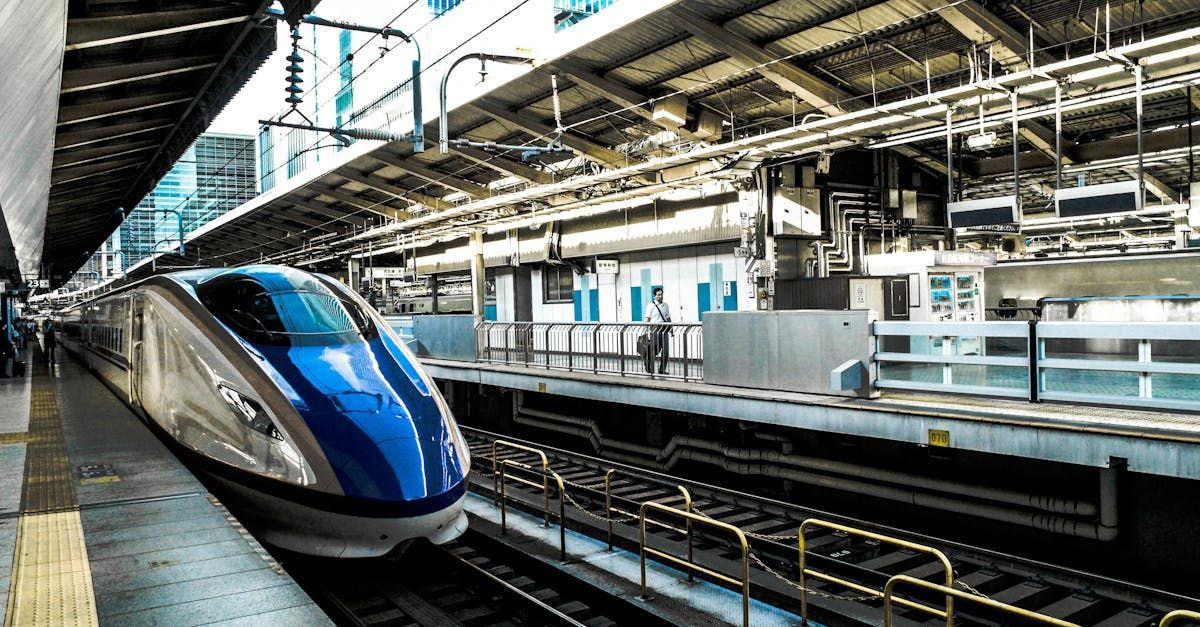 High-speed train in a station, blue and silver, ready to depart. Powered by Sky-Walker High-speed train in a station, blue and silver, ready to depart. Powered by Sky-Walker