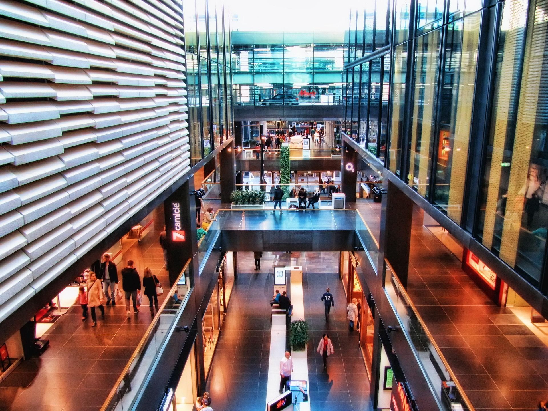 A multi-level shopping center interior with modern architecture, glass railings, and people walking on polished floors. Building management Sky-Walker A multi-level shopping center interior with modern architecture, glass railings, and people walking on polished floors. Building management Sky-Walker
