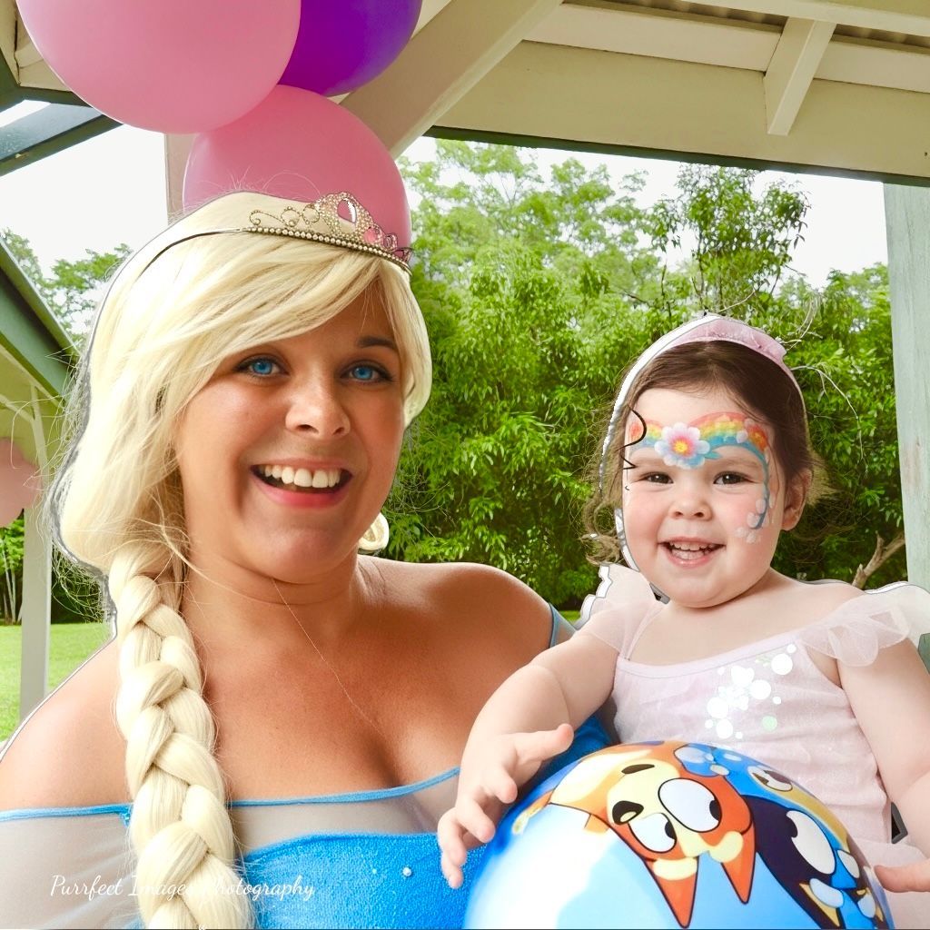 Woman in Elsa Costume Smiles With a Child in Princess Costume, Holding a Beach Ball — Costumes Galore in Maroochydore, QLD