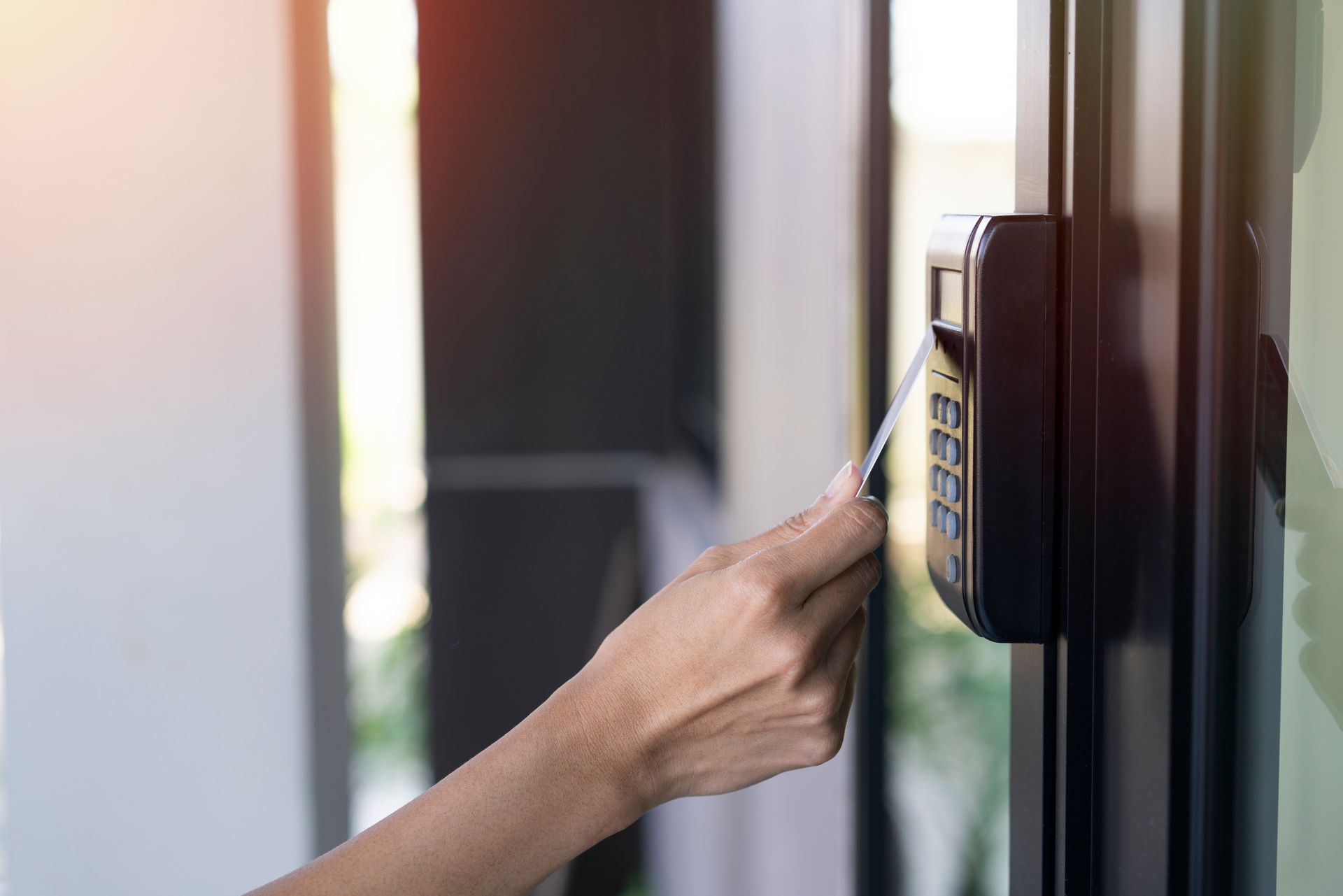 woman taping key card onto access control to open the building door.