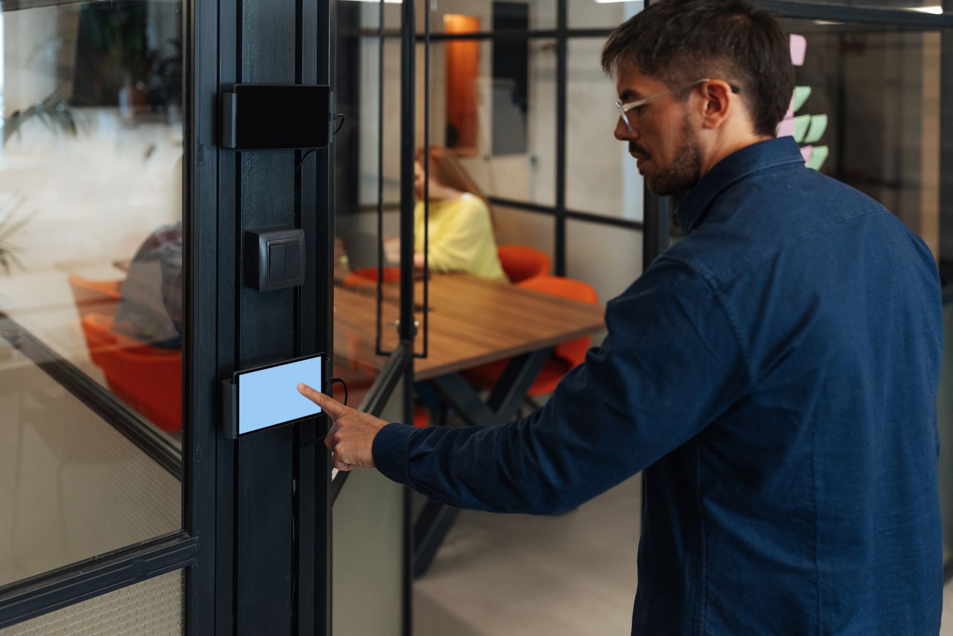 Businessman using electronic control panel for office access with blank screen.
