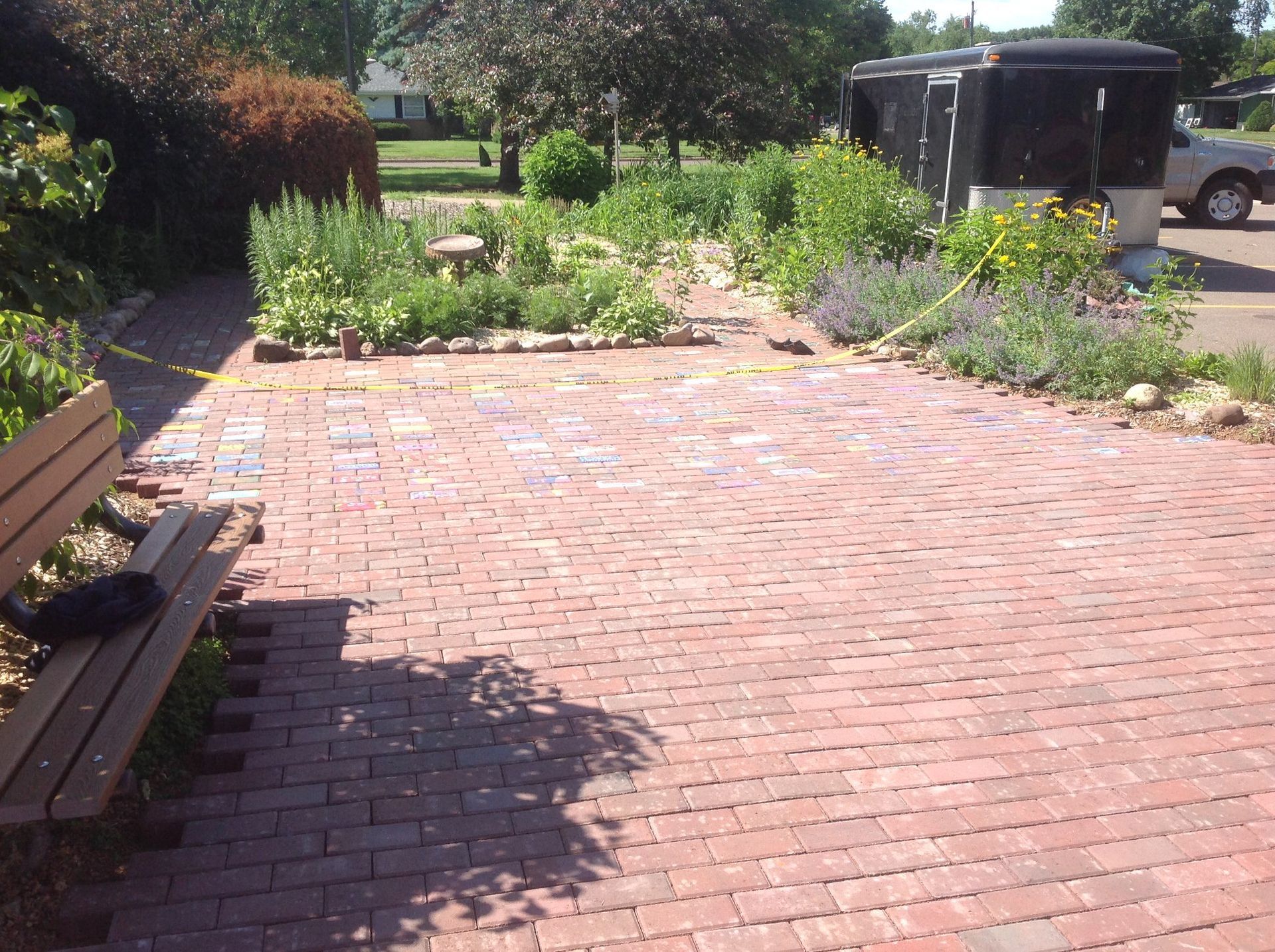 A brick walkway with a bench in the foreground