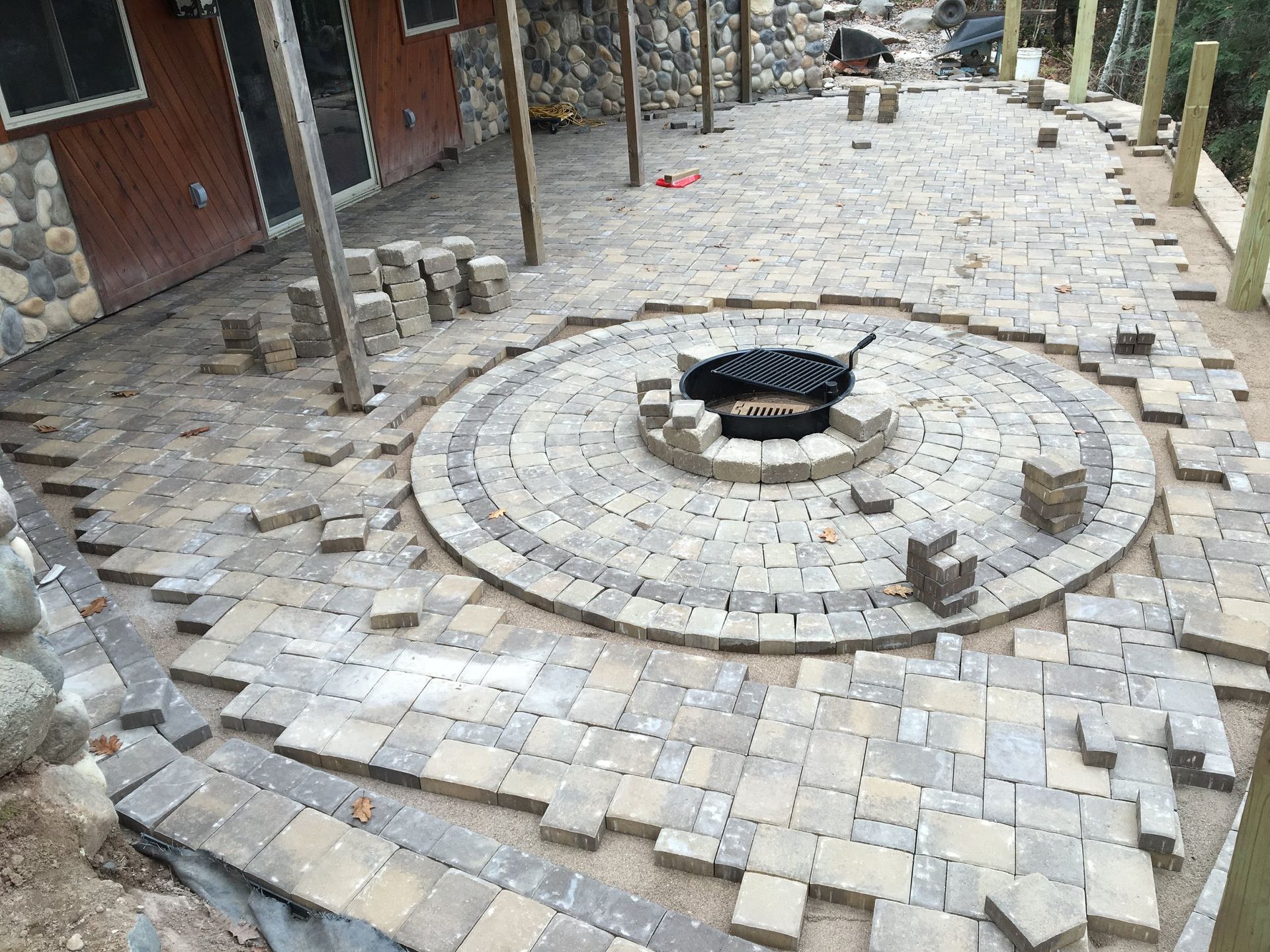 A fire pit is being built in the middle of a patio.