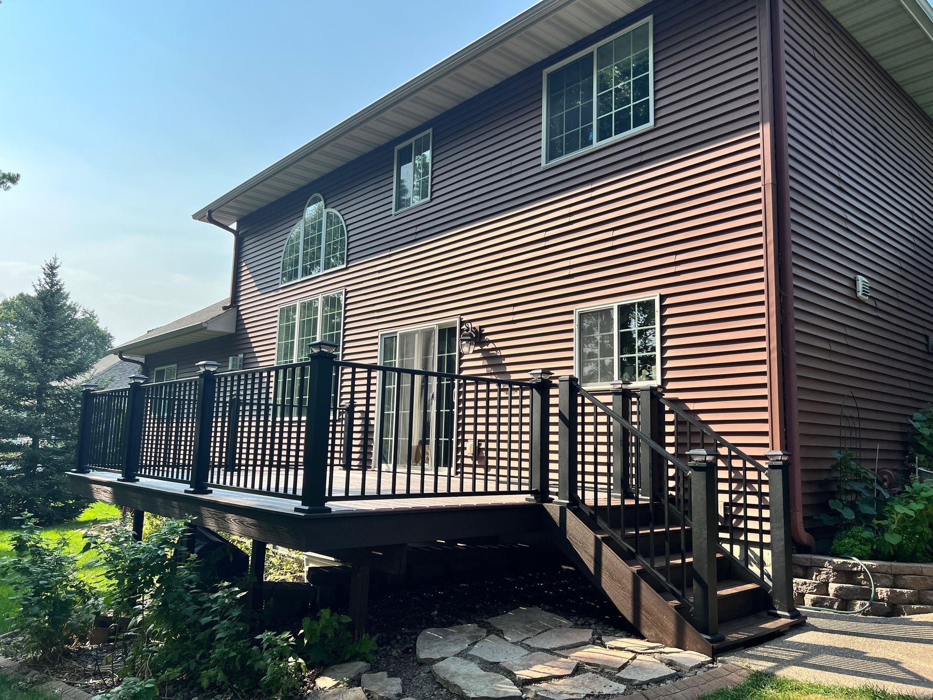 The back of a house with a large deck and stairs