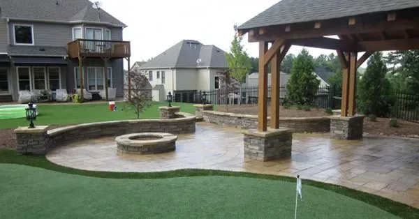 A backyard with a fire pit and a putting green