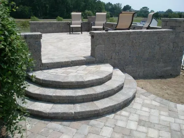 A set of stairs leading up to a patio with chairs