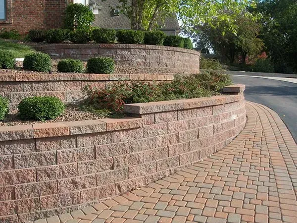A brick wall with a brick walkway in front of a house