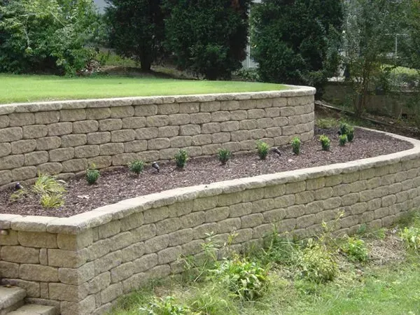 A brick wall with a planter in the middle of it.