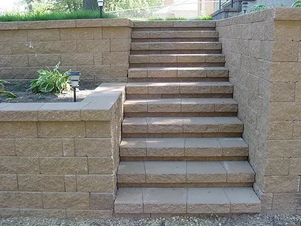 A set of stairs leading up to a brick wall.