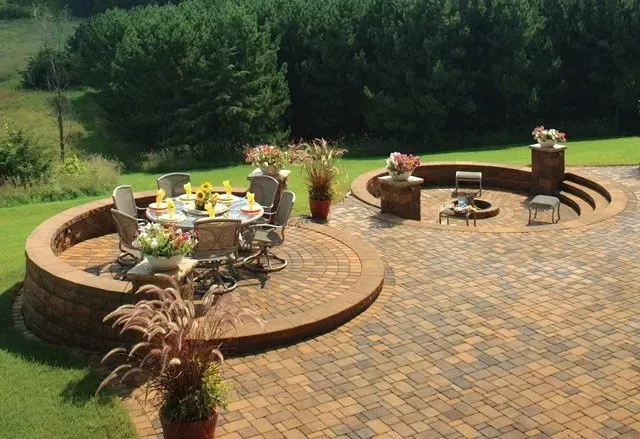 A patio with a table and chairs and a fire pit