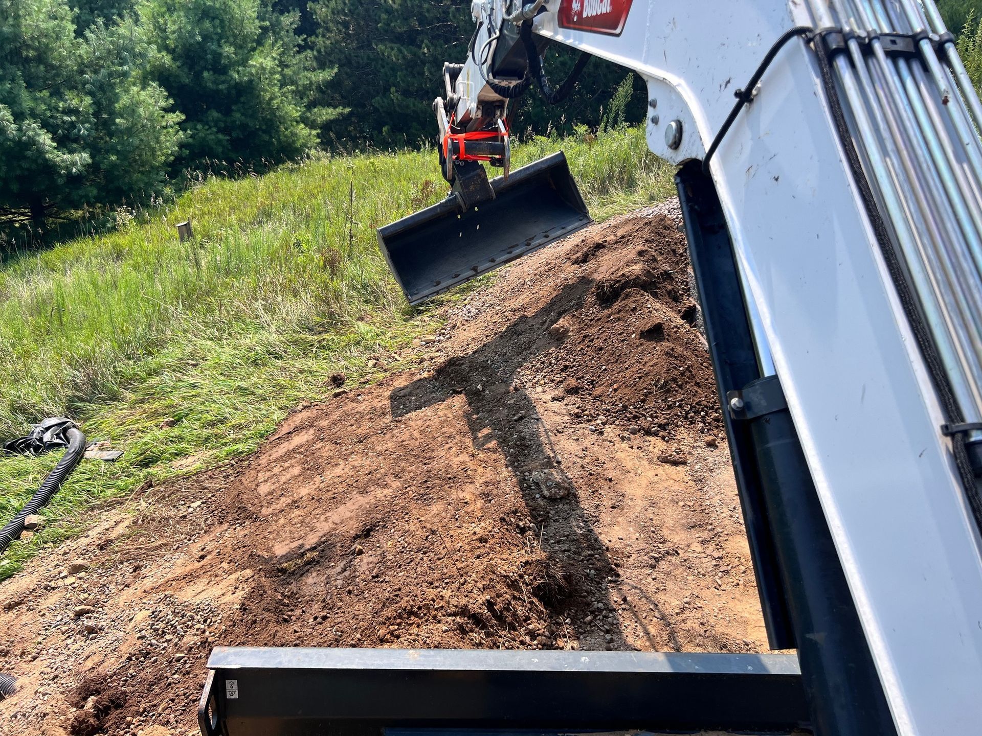 A bulldozer is digging a hole in the dirt on a hill.