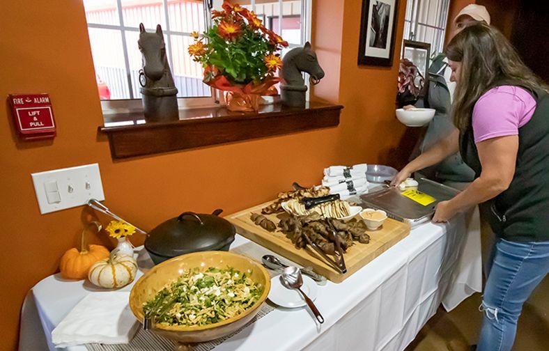 Woman serving food from a buffet table in a dining room