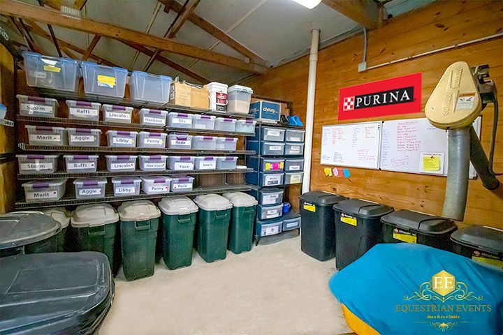 Storage room with stacked bins, plastic tubs, and pet supplies along wall shelves under a Purina sign.