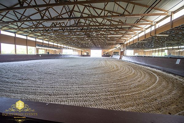 Large indoor barn with a circular bed of grain under a metal truss roof