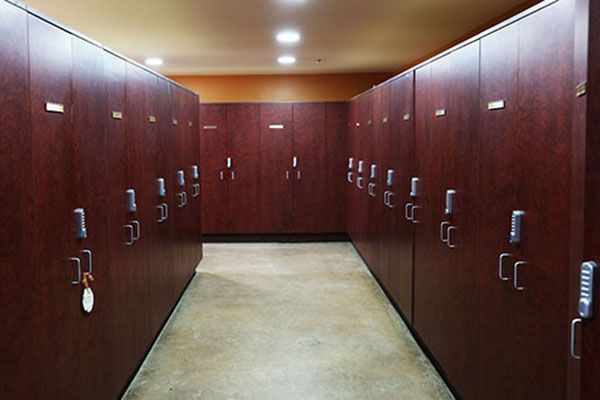 A narrow hallway lined with wooden storage lockers or cabinets on both sides.