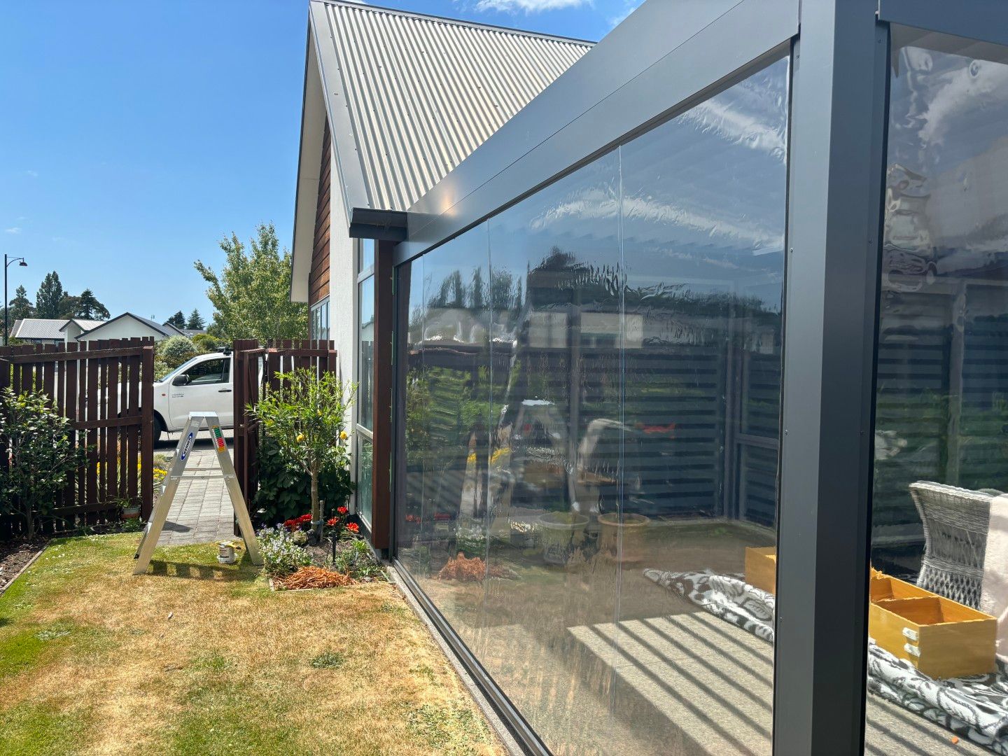 A house with a large glass wall surrounding it.