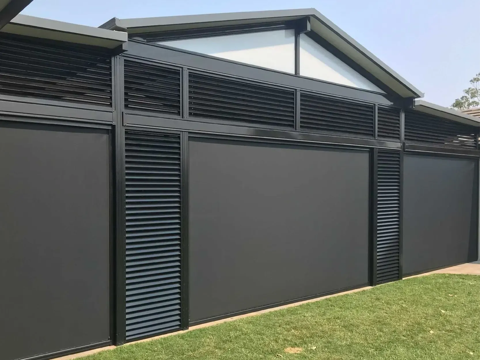 A black fence with shutters on it is in front of a house.