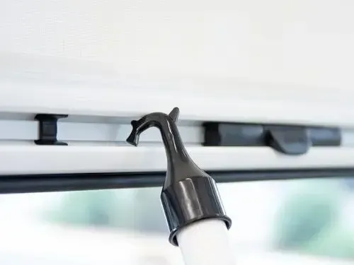 A hook is hanging from the ceiling of a vehicle.