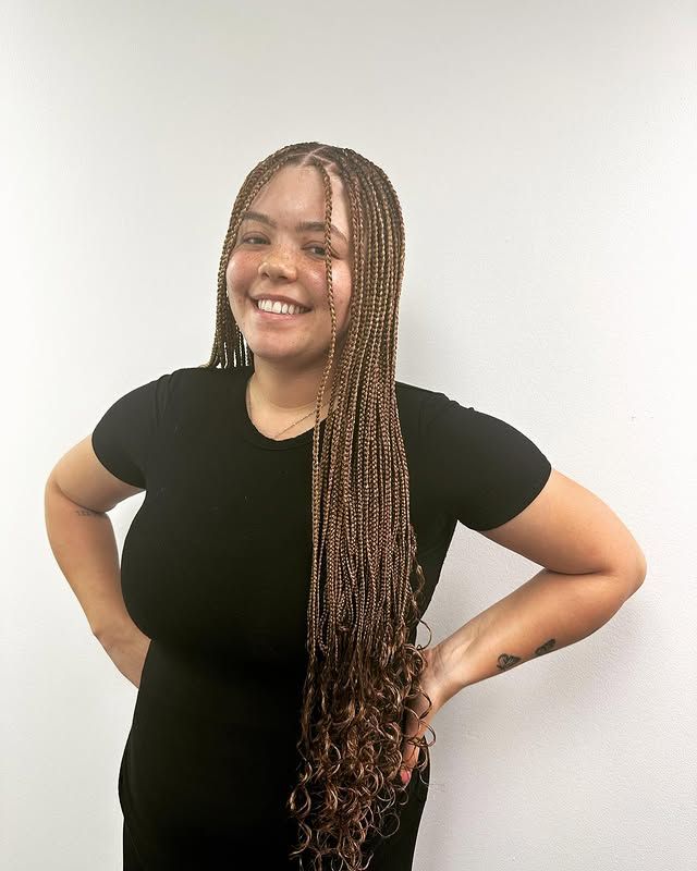 Person smiling with hands on hips, wearing a black shirt against a plain white background