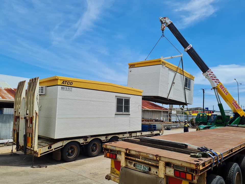 A Crane Lifting a White Modular Office Building — Bell's Carrying & Crane Hire Service Pty Ltd in Bungalow, QLD