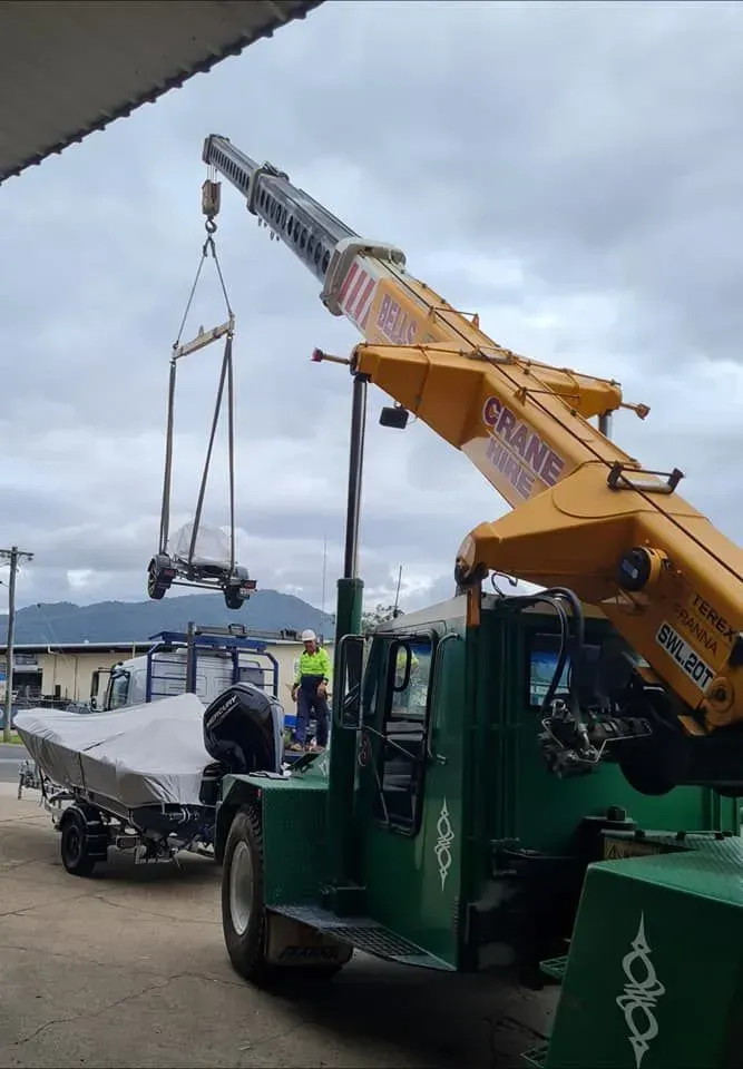 A Crane Lifting a Silver Object — Bell's Carrying & Crane Hire Service Pty Ltd in Port Douglas, QLD