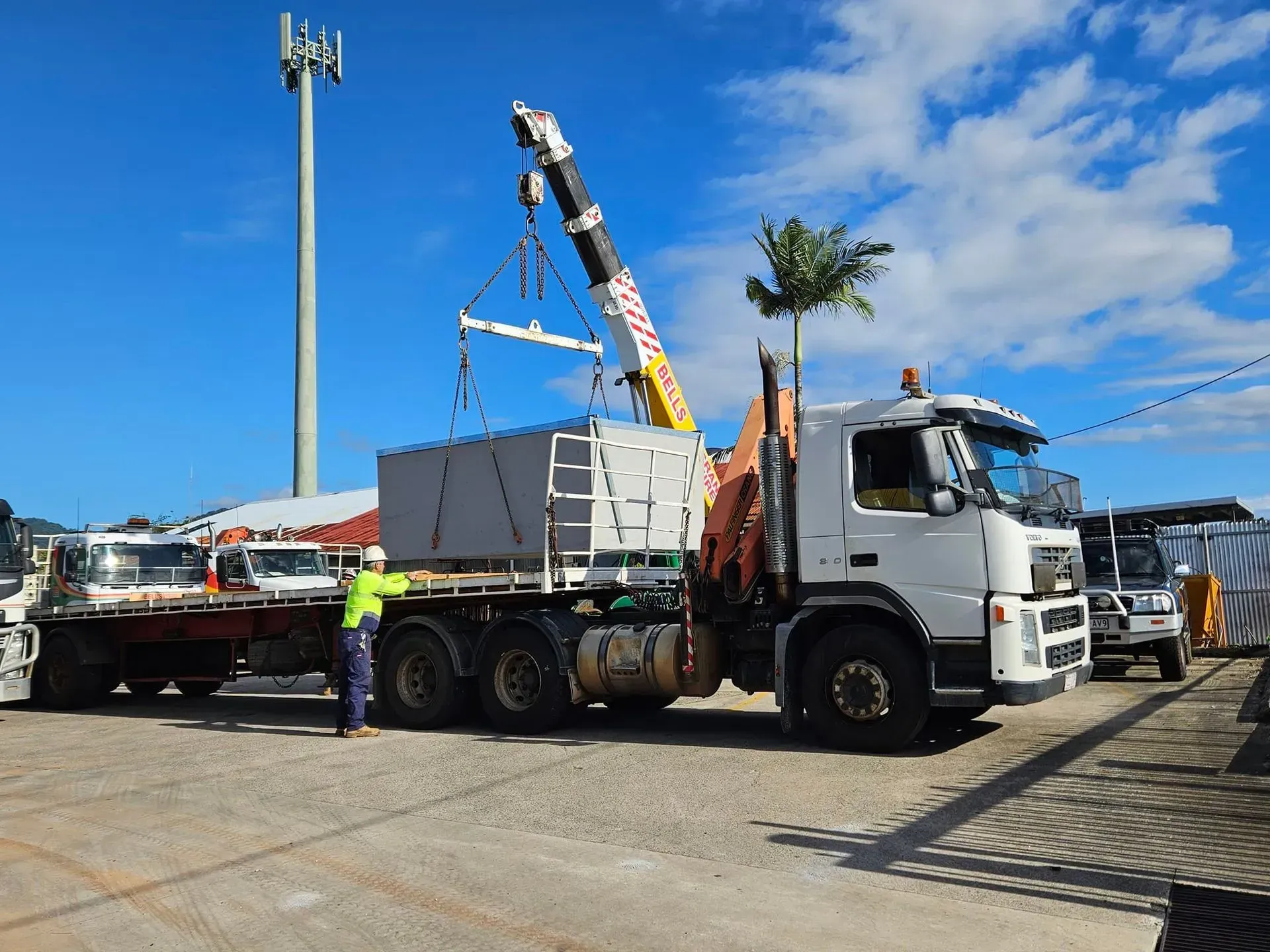 Crane Lifting a Large Grey Container — Bell's Carrying & Crane Hire Service Pty Ltd in Chillagoe, QLD