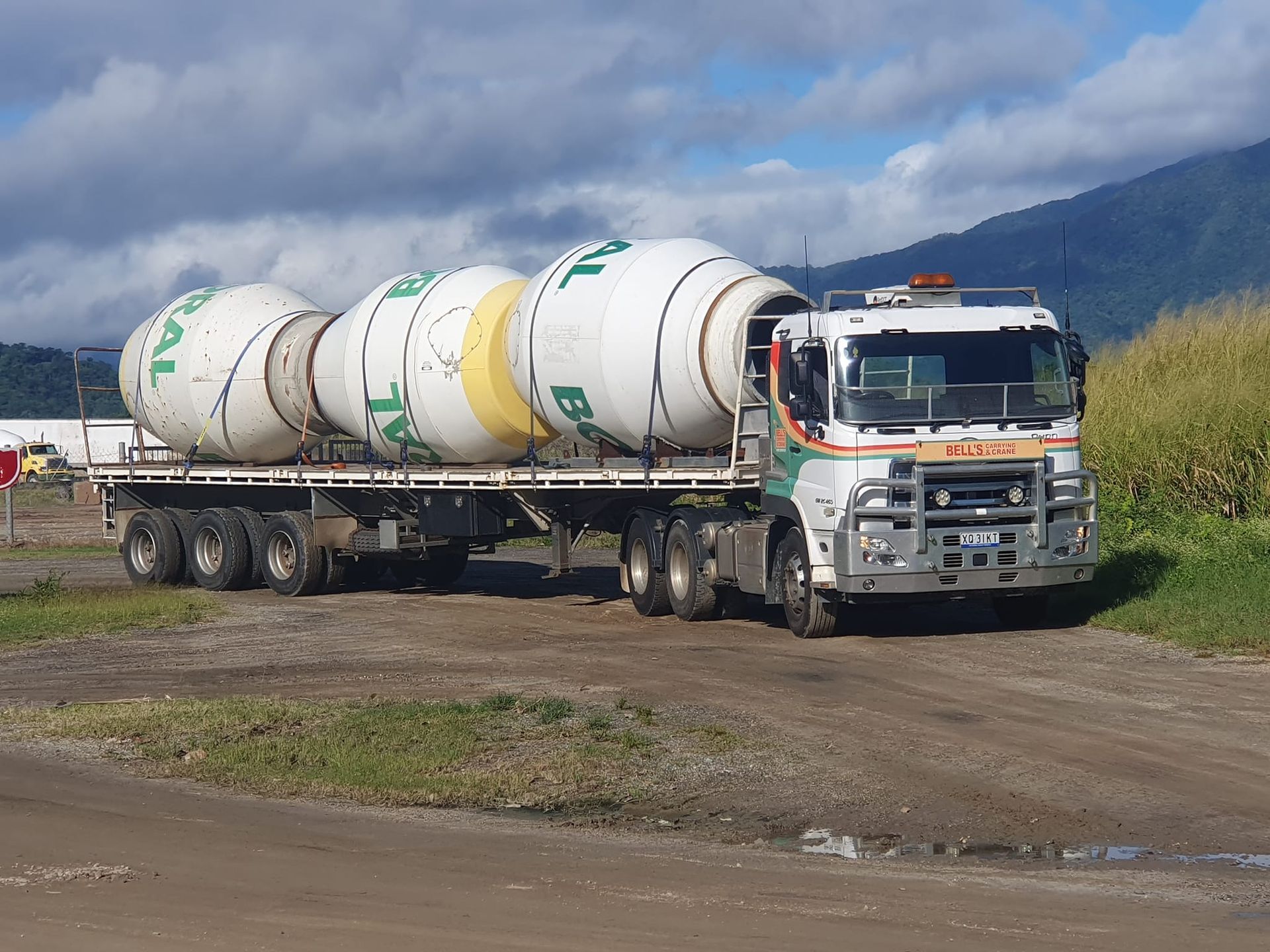 Cement Mixer Truck Carrying Three White Tanks — Bell's Carrying & Crane Hire Service Pty Ltd in Bungalow, QLD