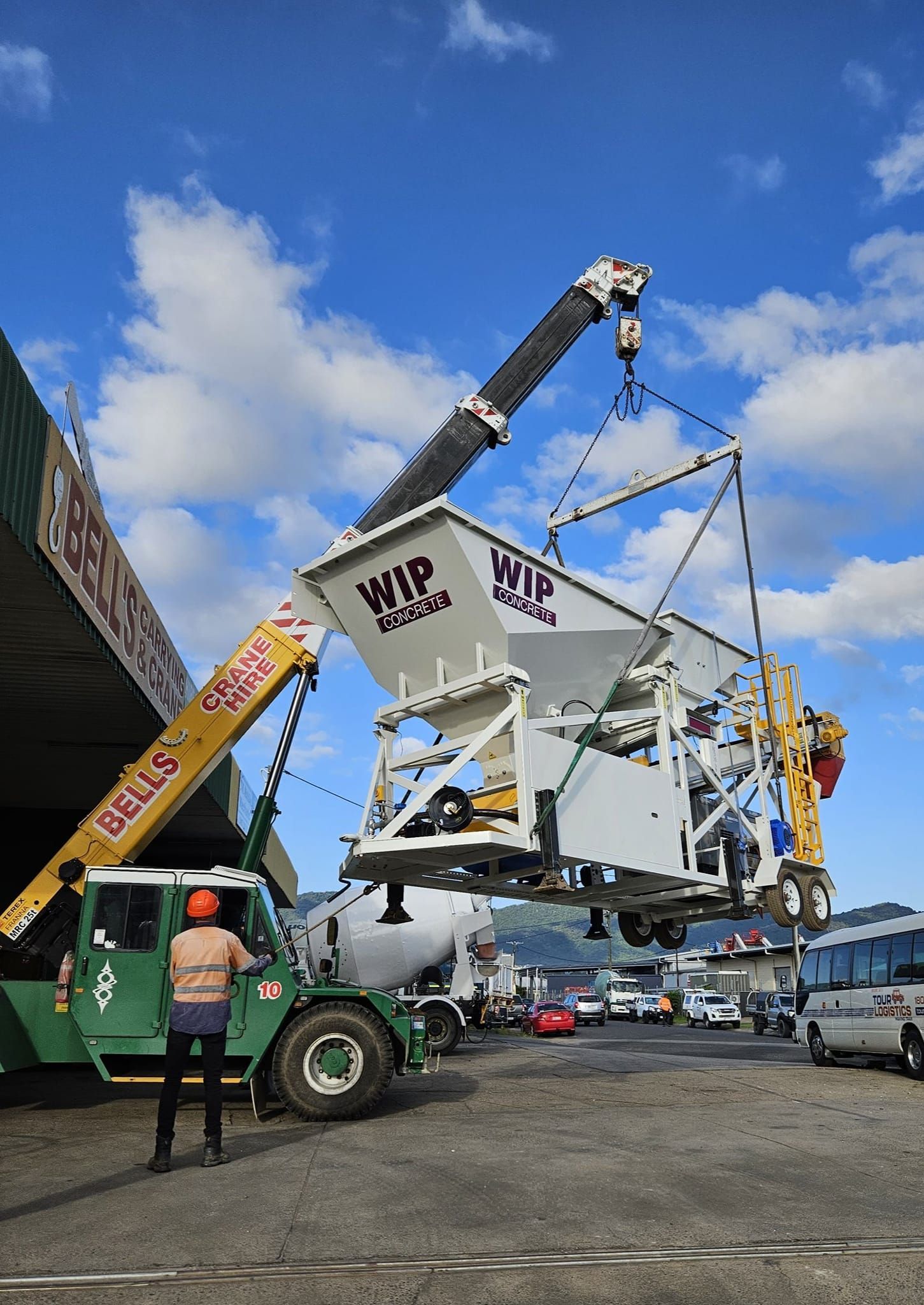 A Crane Lifts a Large White Cement Mixer — Bell's Carrying & Crane Hire Service Pty Ltd in Bungalow, QLD
