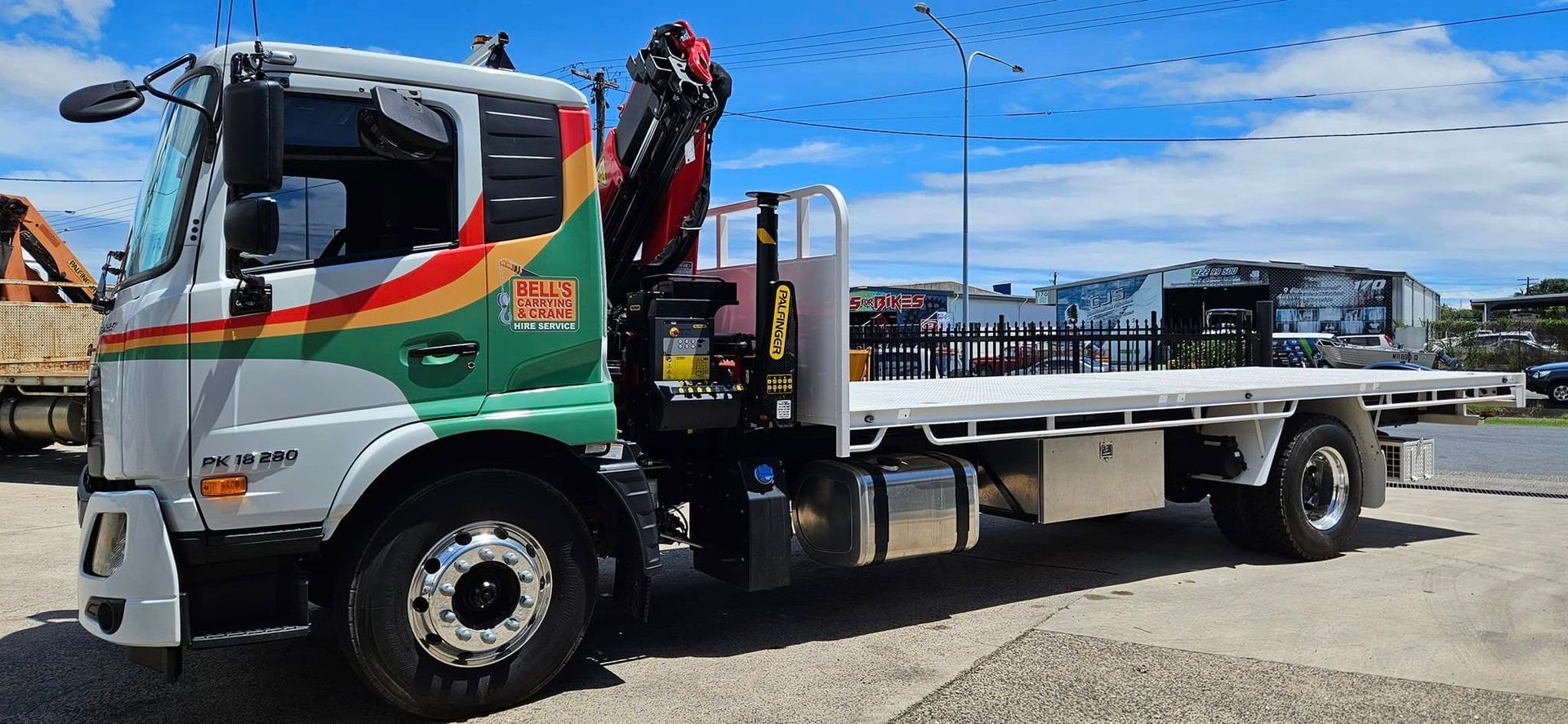 A White Flatbed Truck — Bell's Carrying & Crane Hire Service Pty Ltd in Bungalow, QLD