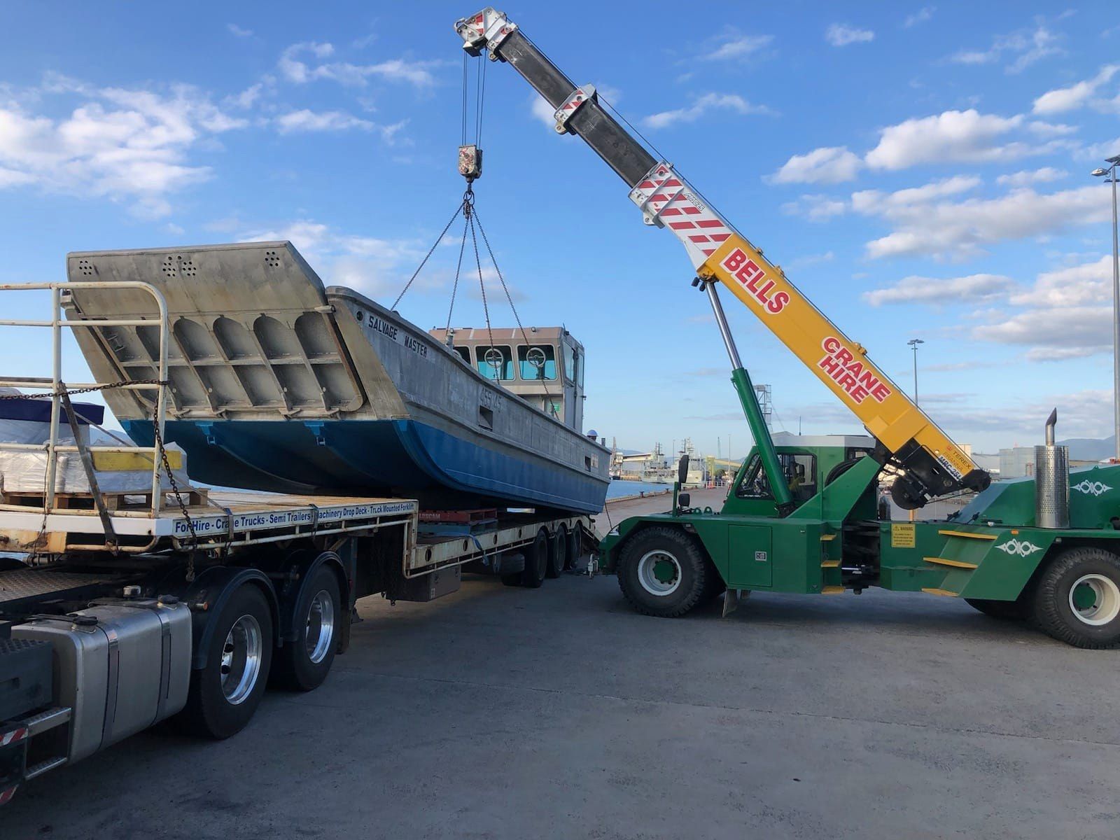 A Crane Lifts a Large Blue — Bell's Carrying & Crane Hire Service Pty Ltd in Atherton, QLD