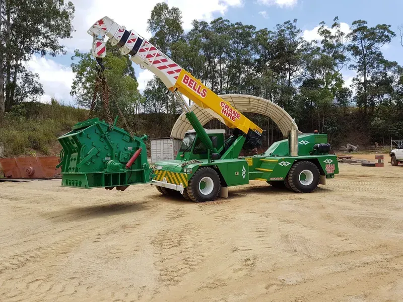 Green Crane Lifting a Large Green Industrial Machine — Bell's Carrying & Crane Hire Service Pty Ltd in Bungalow, QLD