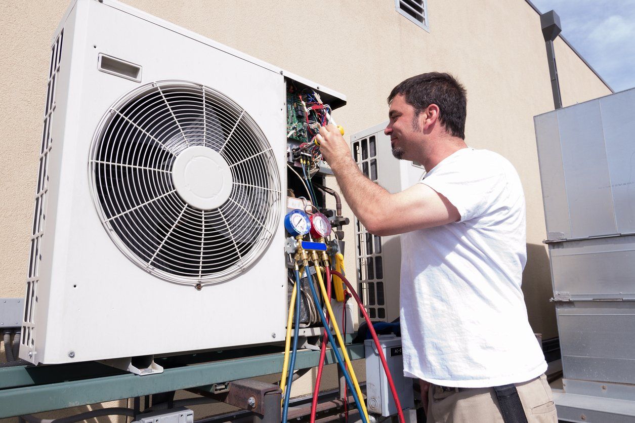 Person Installing a Ductless Air Conditioning System in Queens, NY