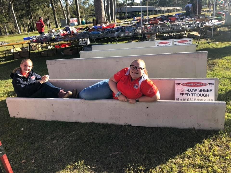Two Women Are Laying on a High Low Sheep Feed Through — Graham's Precast Concrete Products Pty Ltd in Kyogle, NSW