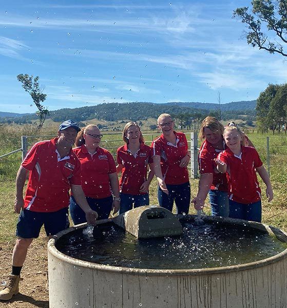 A Group of People Are Standing Around a Large Tank of Water — Graham's Precast Concrete Products Pty Ltd in Kyogle, NSW