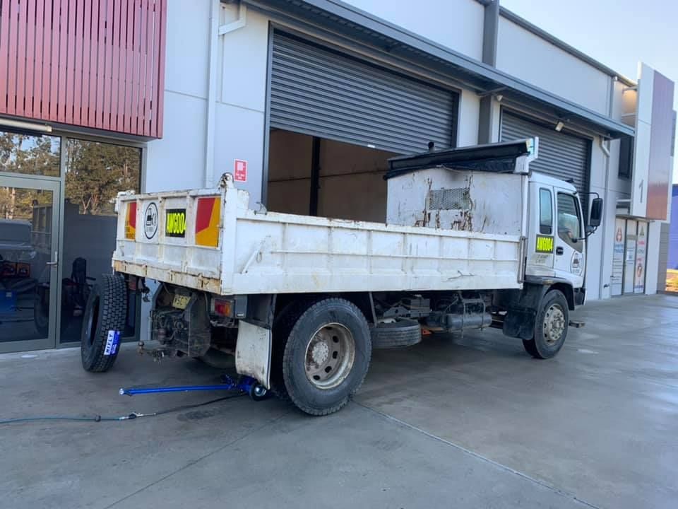 White Dump Truck Parked Beside a Warehouse — Gardiner Automotive & Performance in Rutherford, NSW