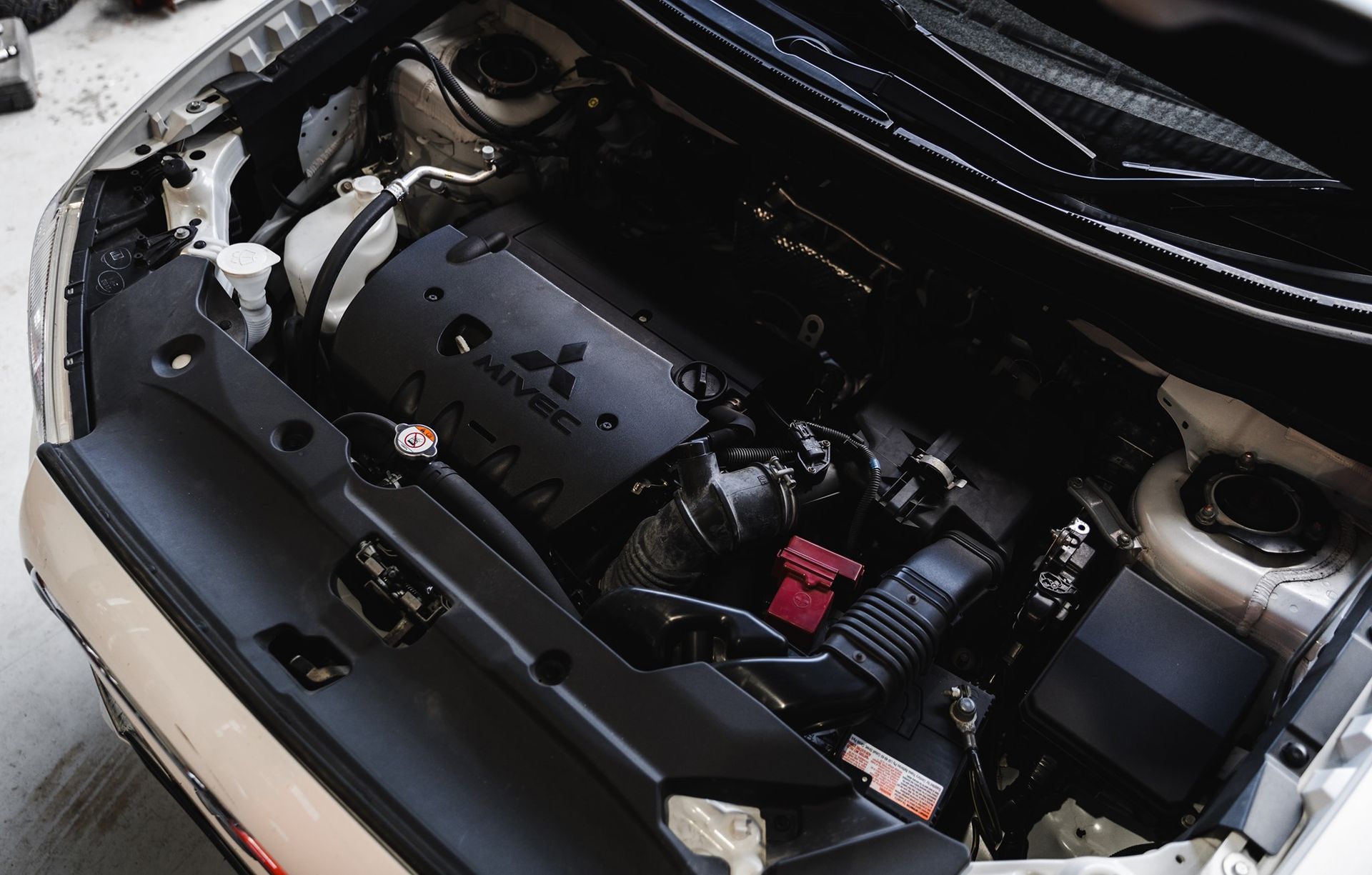 Open Car Hood Showing Engine Bay with Black Engine Cover — Gardiner Automotive & Performance in Maitland, NSW