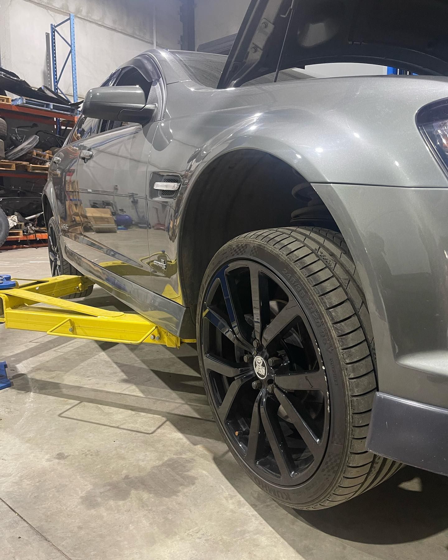 Silver Sports Car on A Yellow Lift in A Garage — Gardiner Automotive & Performance in Rutherford, NSW