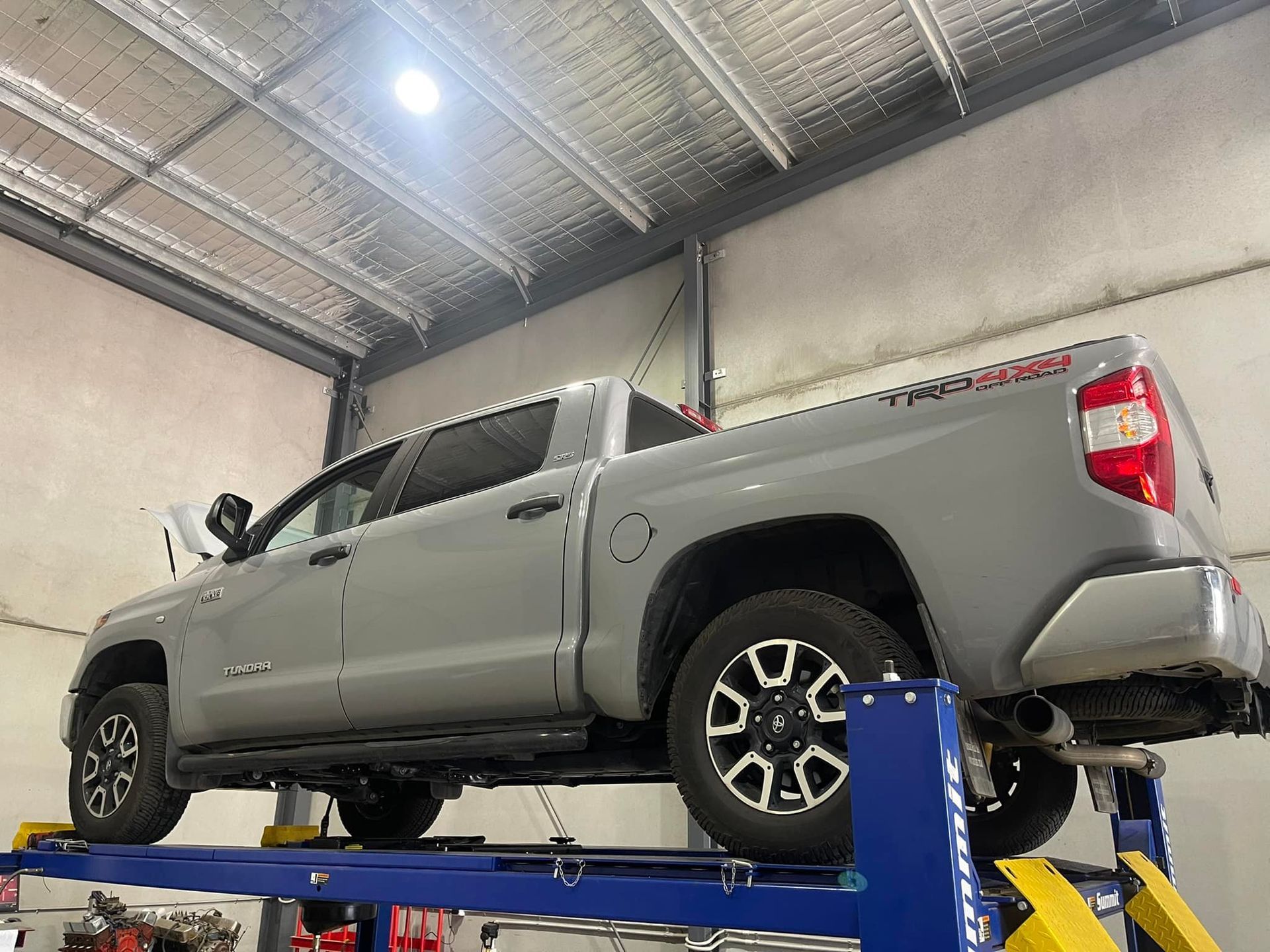 Silver Pickup Truck on A Blue Hydraulic Lift — Gardiner Automotive & Performance in Rutherford, NSW