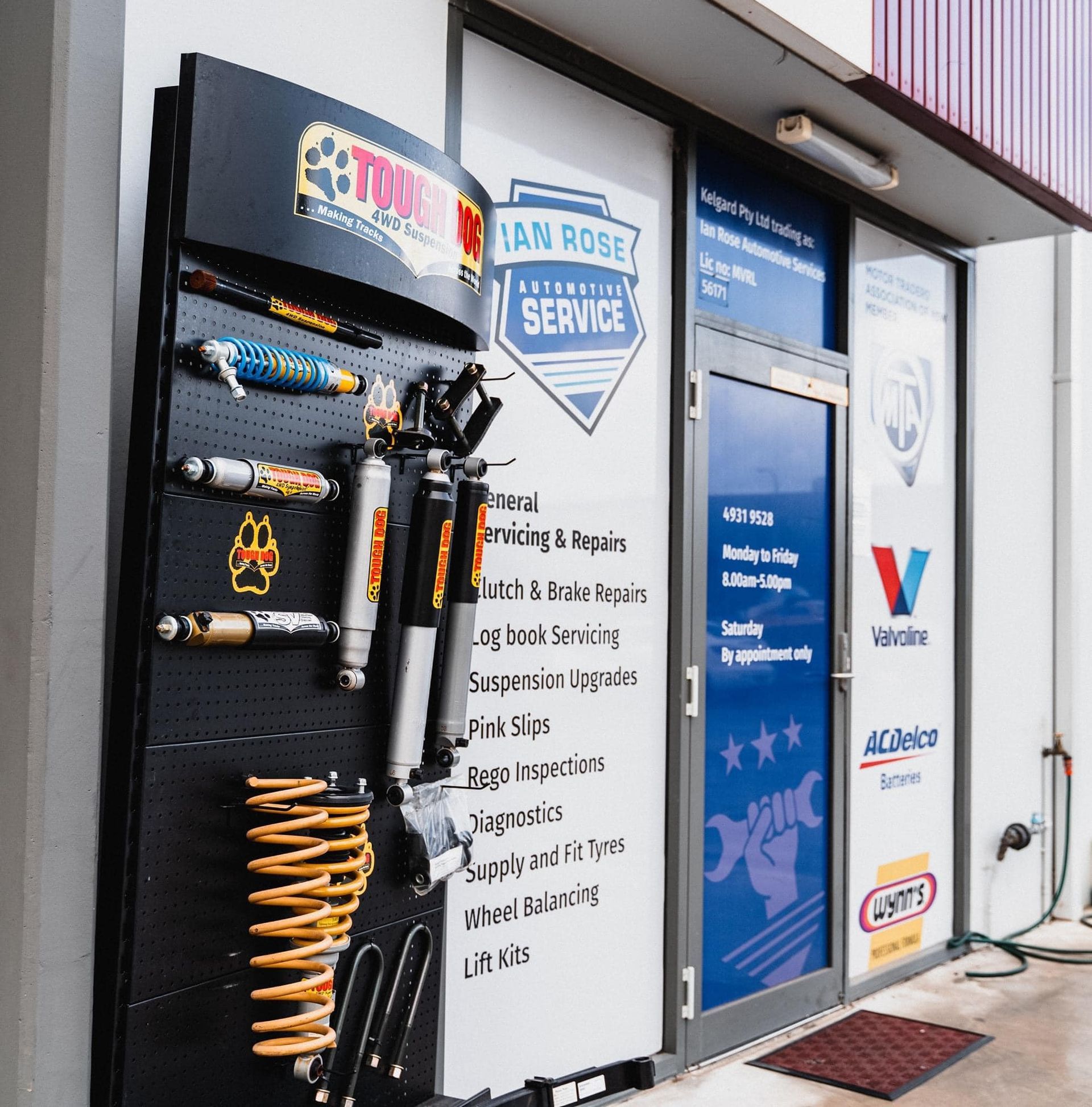 Auto service display with shocks, springs, and shop signs in a garage showroom — Gardiner Automotive & Performance in Rutherford, NSW