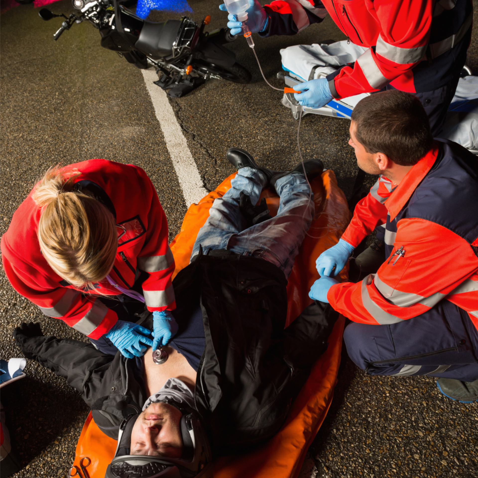 two firefighters are working on a motorcycle accident victim, Portage, IN